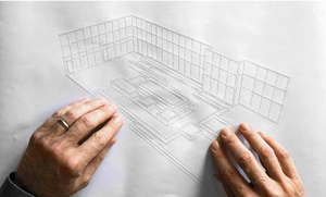 A man is using both of his hands to feel the raised lines of an architectural drawing.