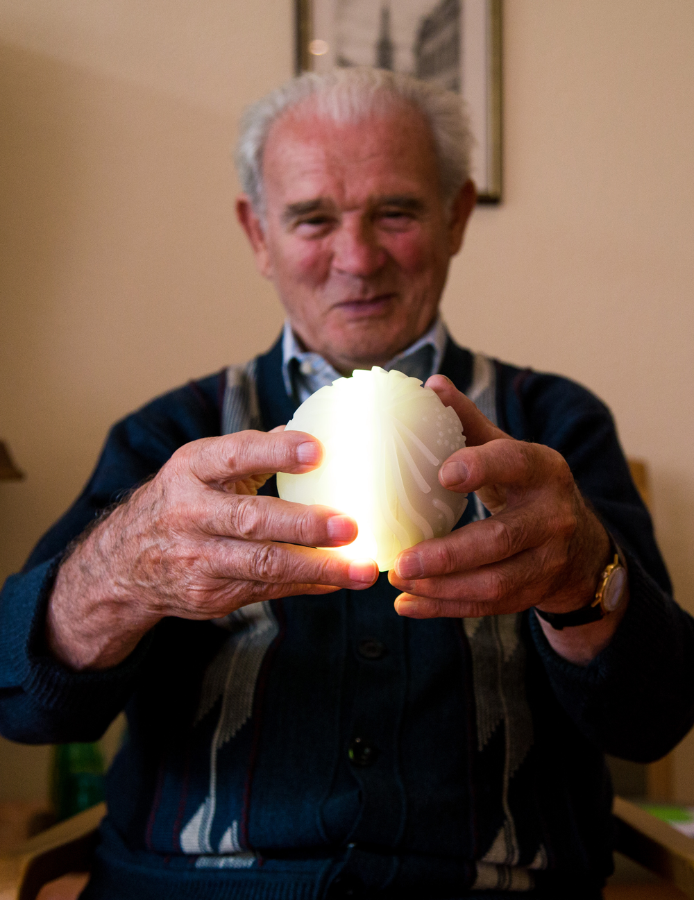 An elderly man holds an illuminated Ichó ball.